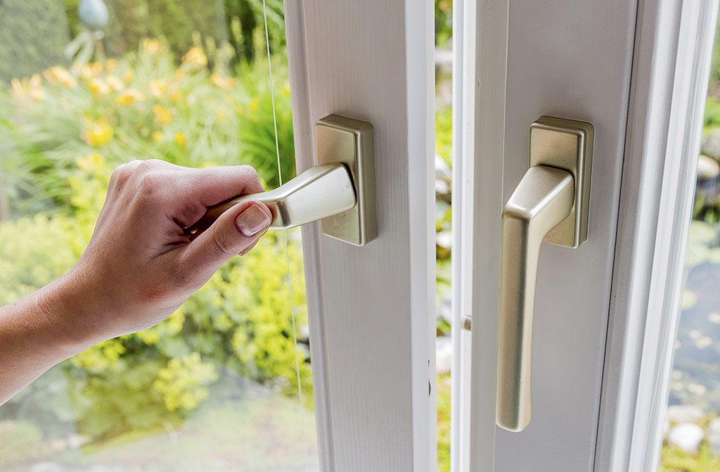 Frau öffnet ein Holz-Aluminium Fenster